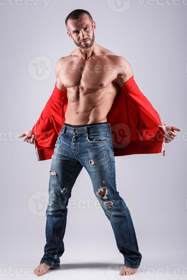 Handsome muscular man posing in studio on gray background photo