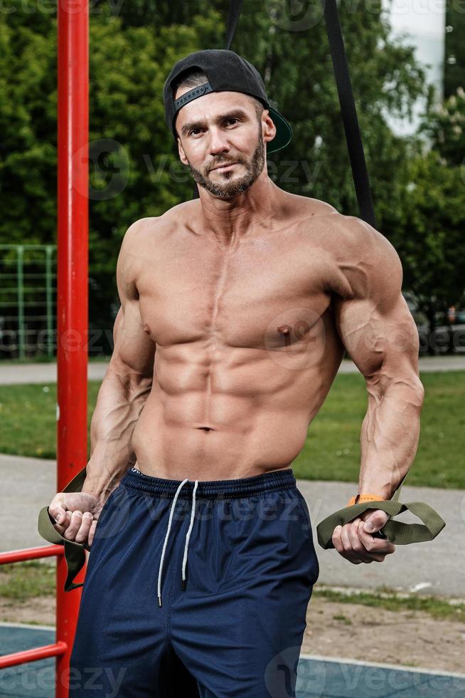 Man during workout with suspension straps on street photo