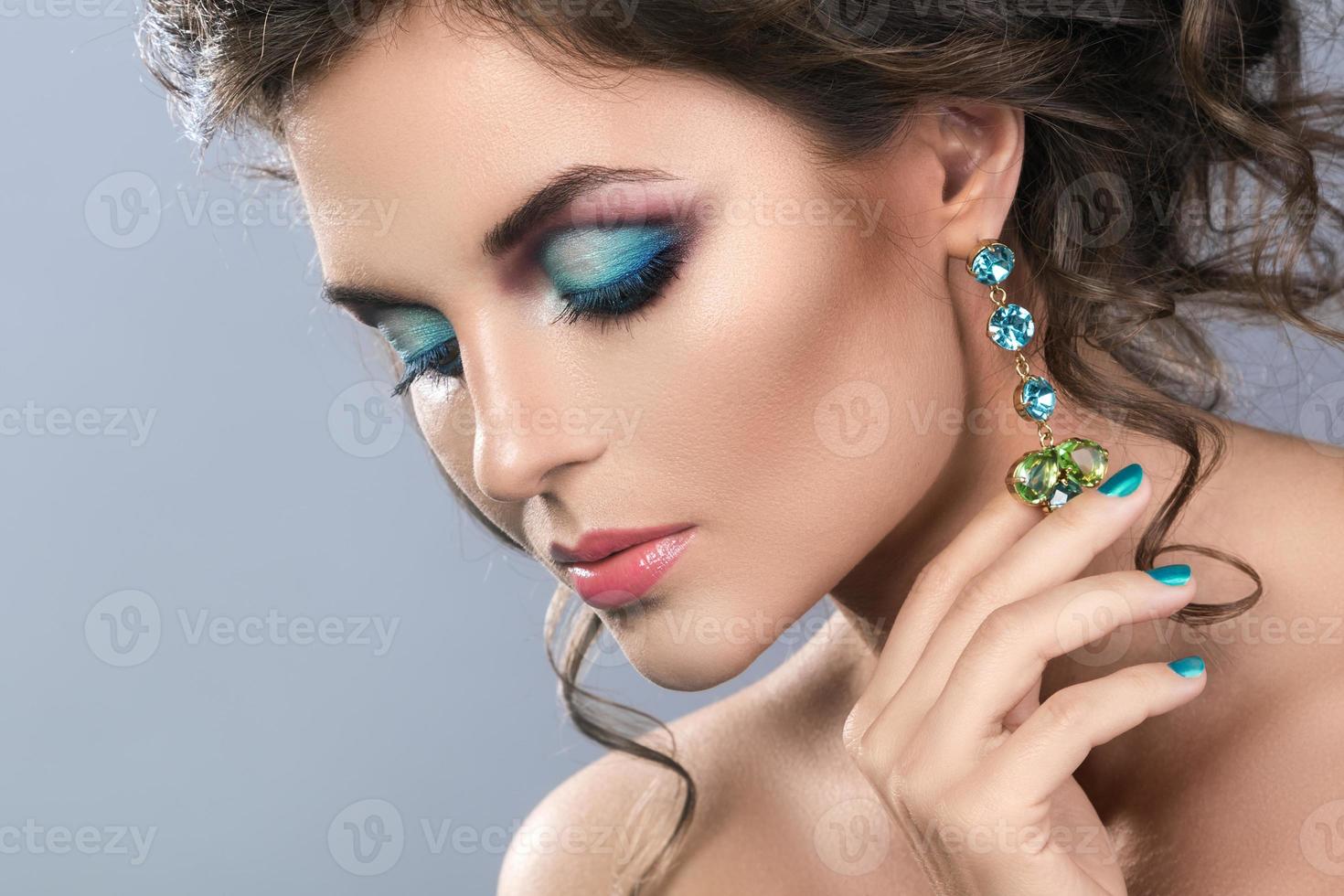 hermosa mujer con aretes brillantes en estudio foto