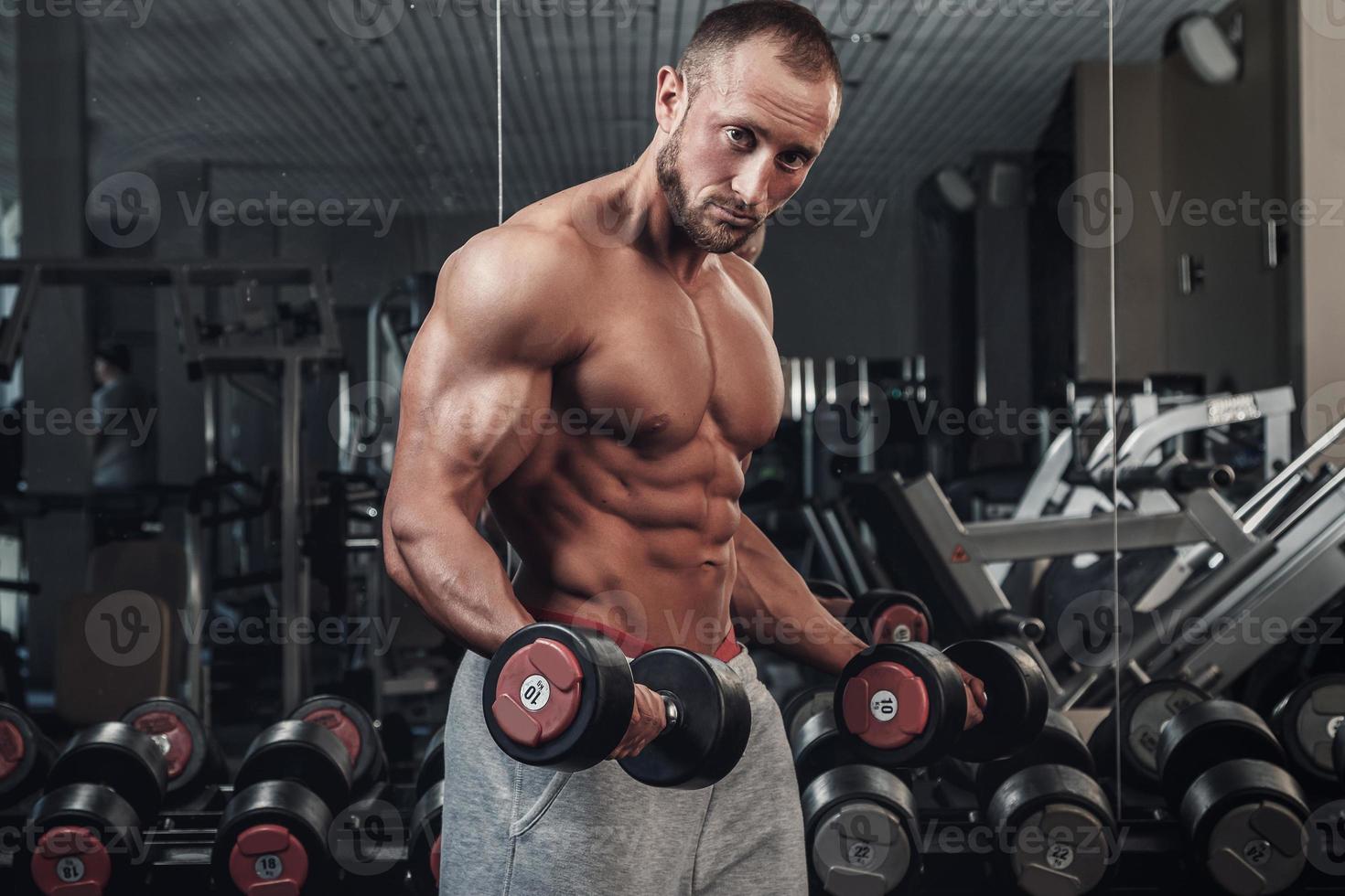 hombre musculoso haciendo un ejercicio para bíceps foto