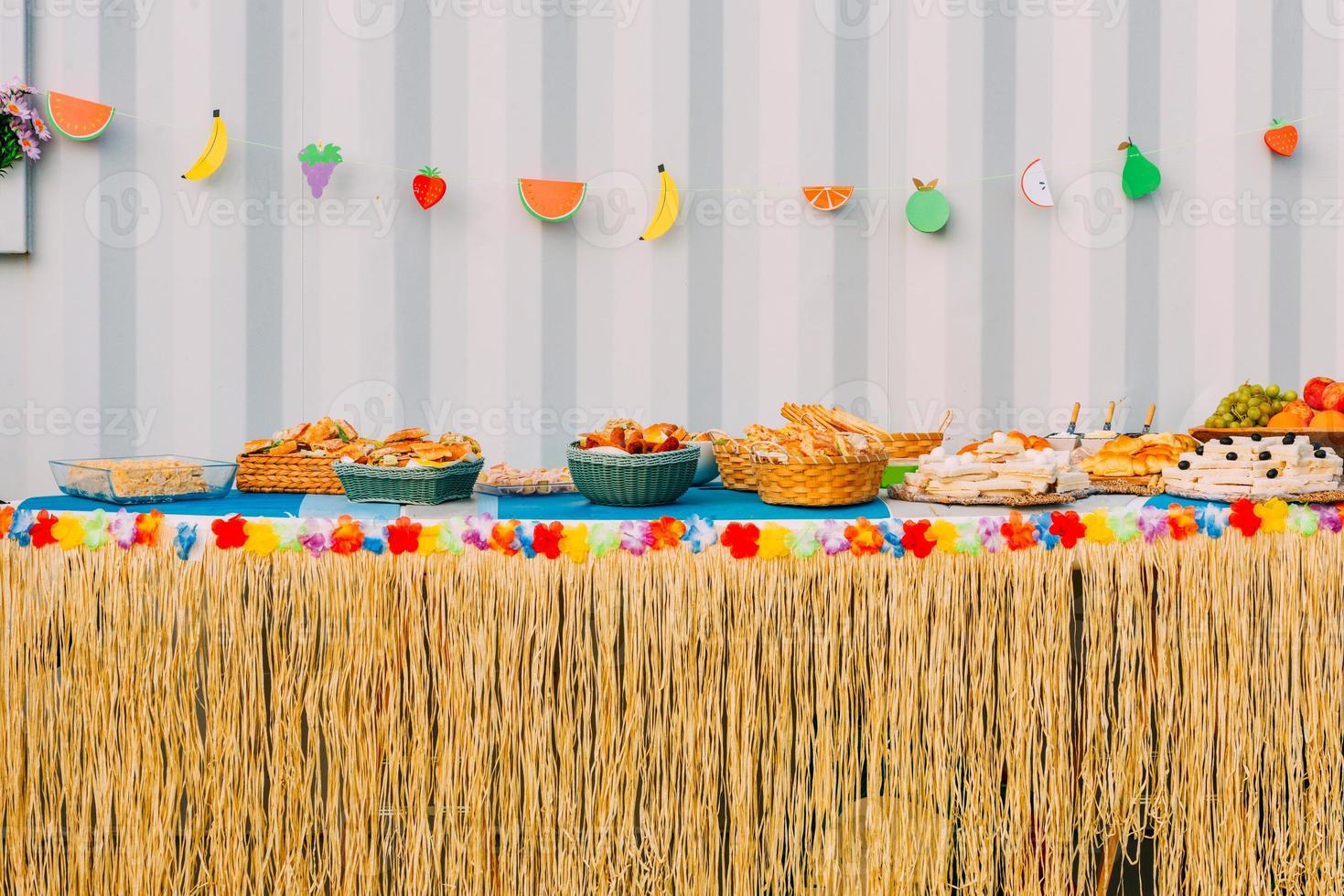 Side view of assortment of finger party food on a table with decorations photo