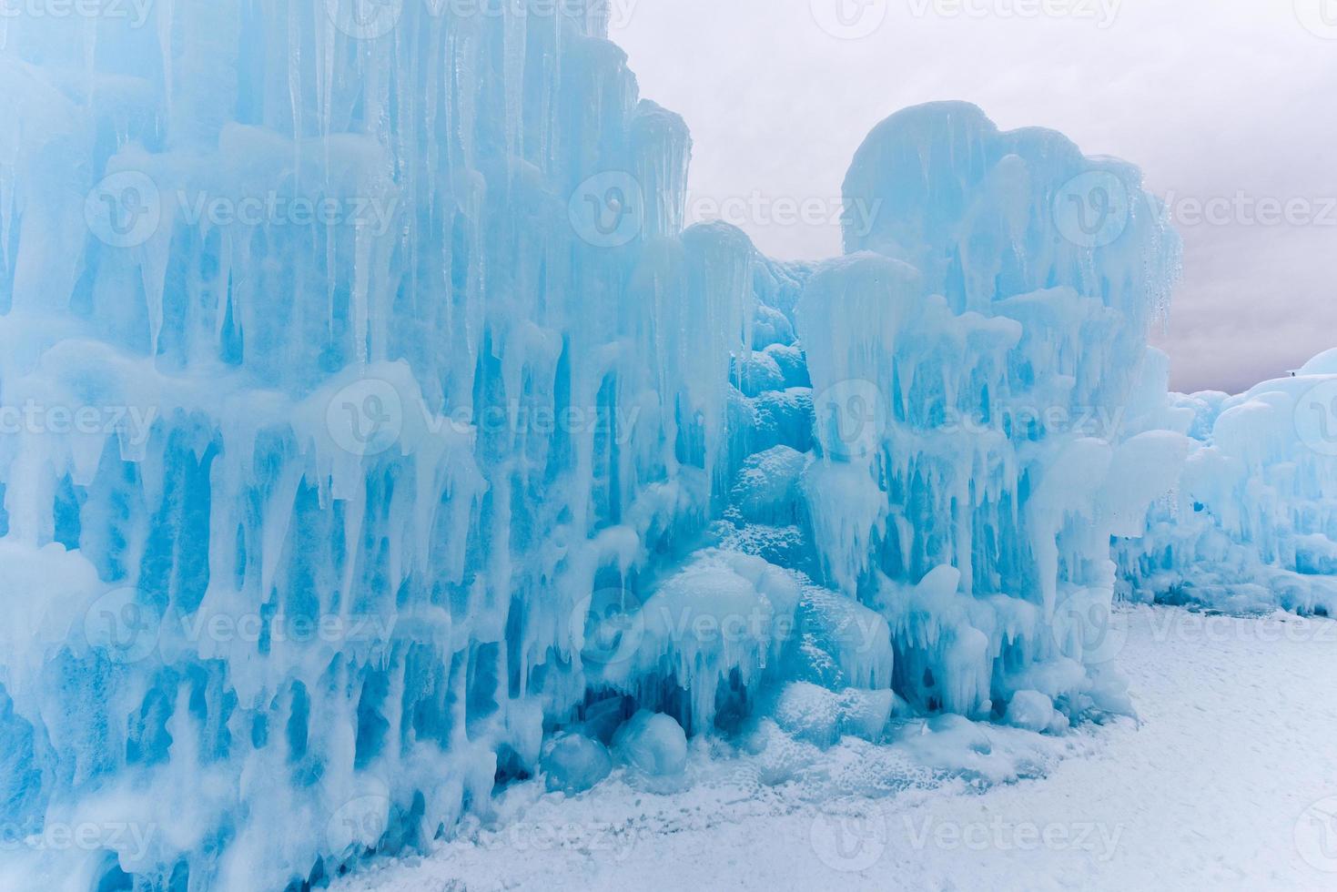 Translucent blue icicles in a frozen ice wall. photo