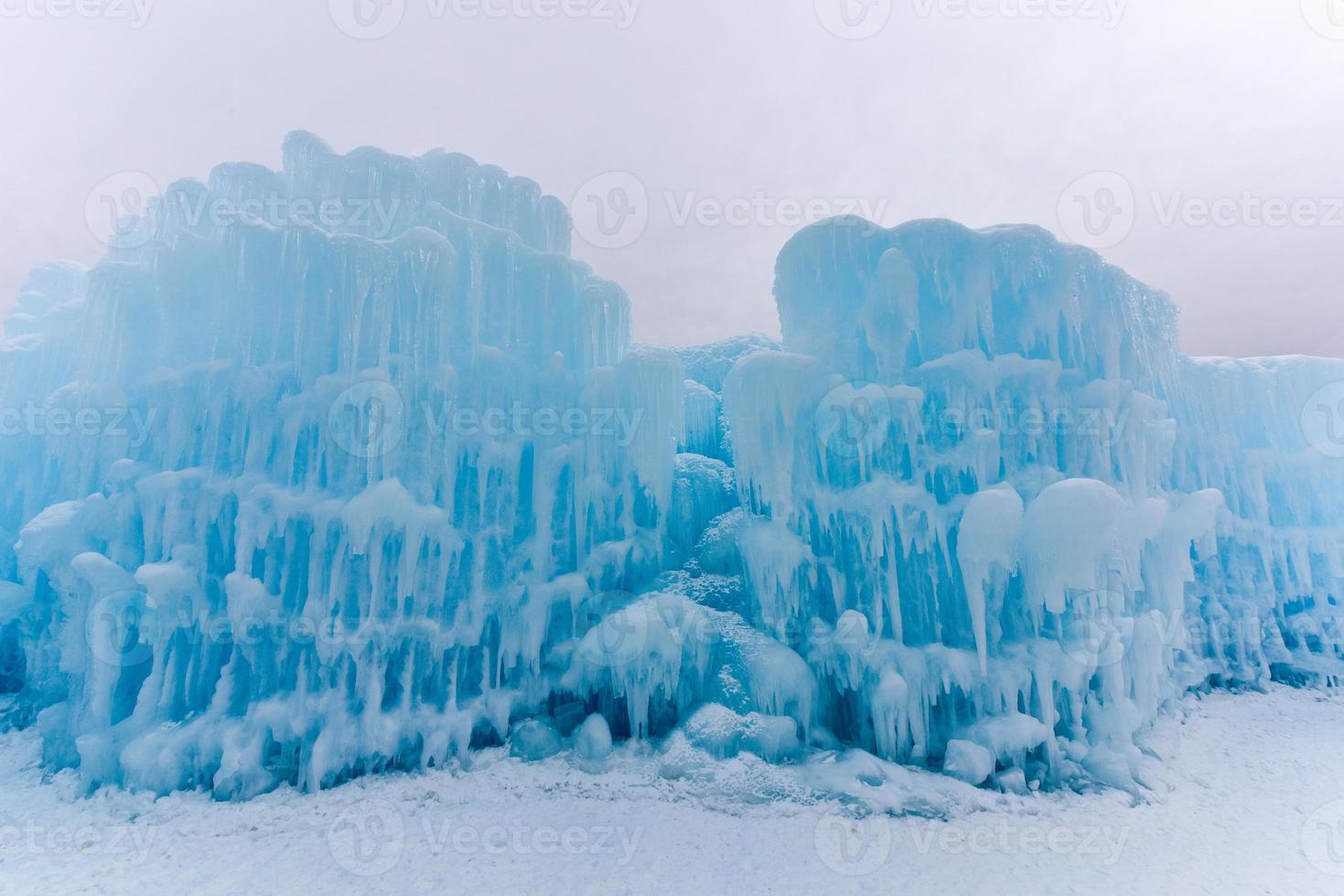 Translucent blue icicles in a frozen ice wall. photo