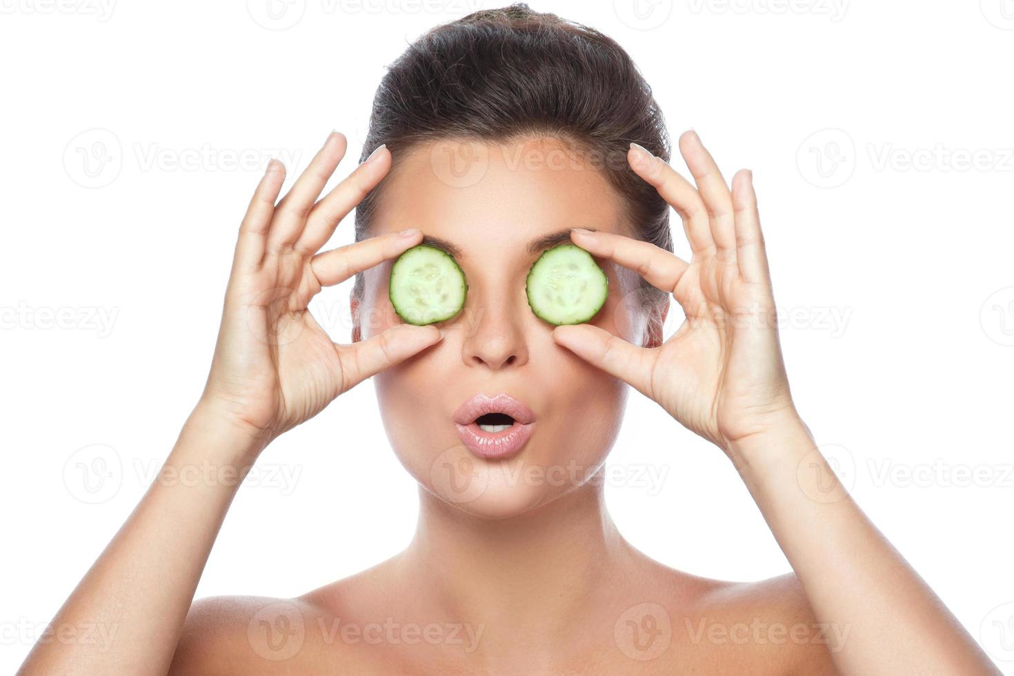 Beautiful woman with cucumber slices on white background photo