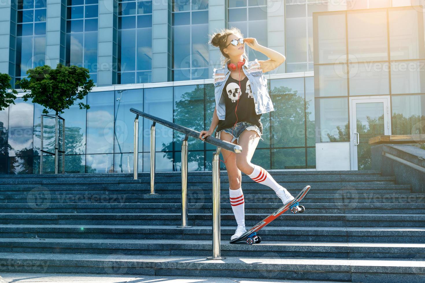 chica elegante con patineta en la calle foto