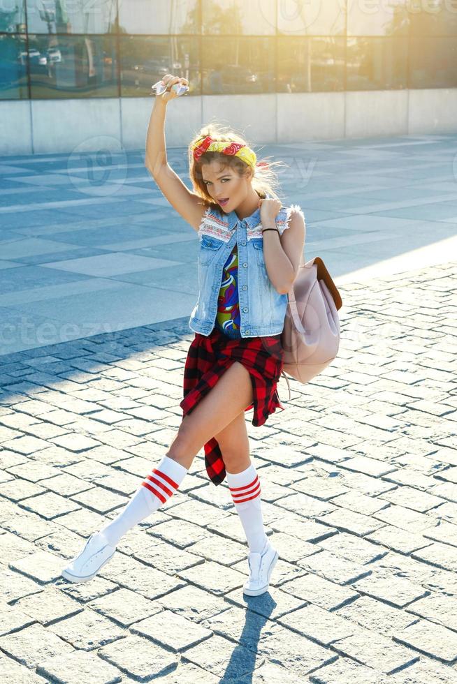 Stylish teenage girl with backpack on the street photo