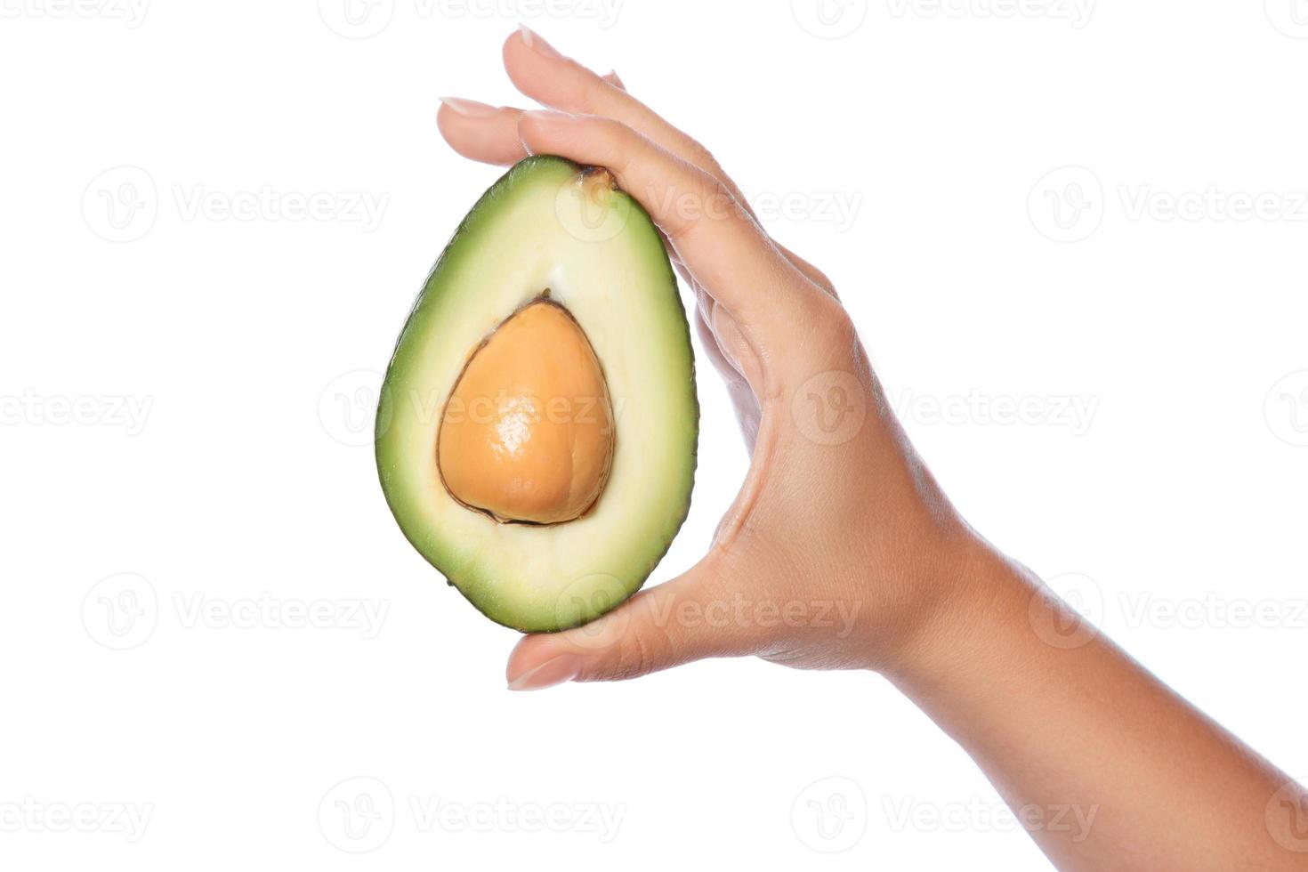 Hand with fresh avocado fruit on white background photo