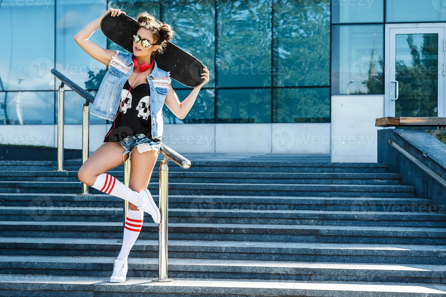 Stylish girl with a skateboard on the street photo