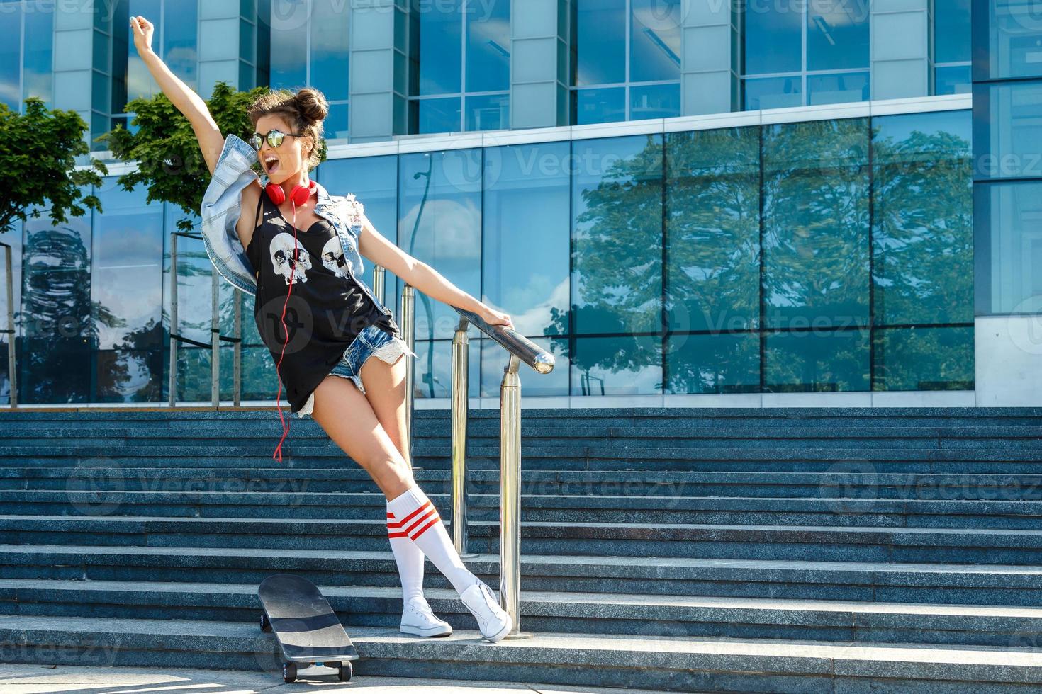 Stylish girl with a skateboard on the street photo