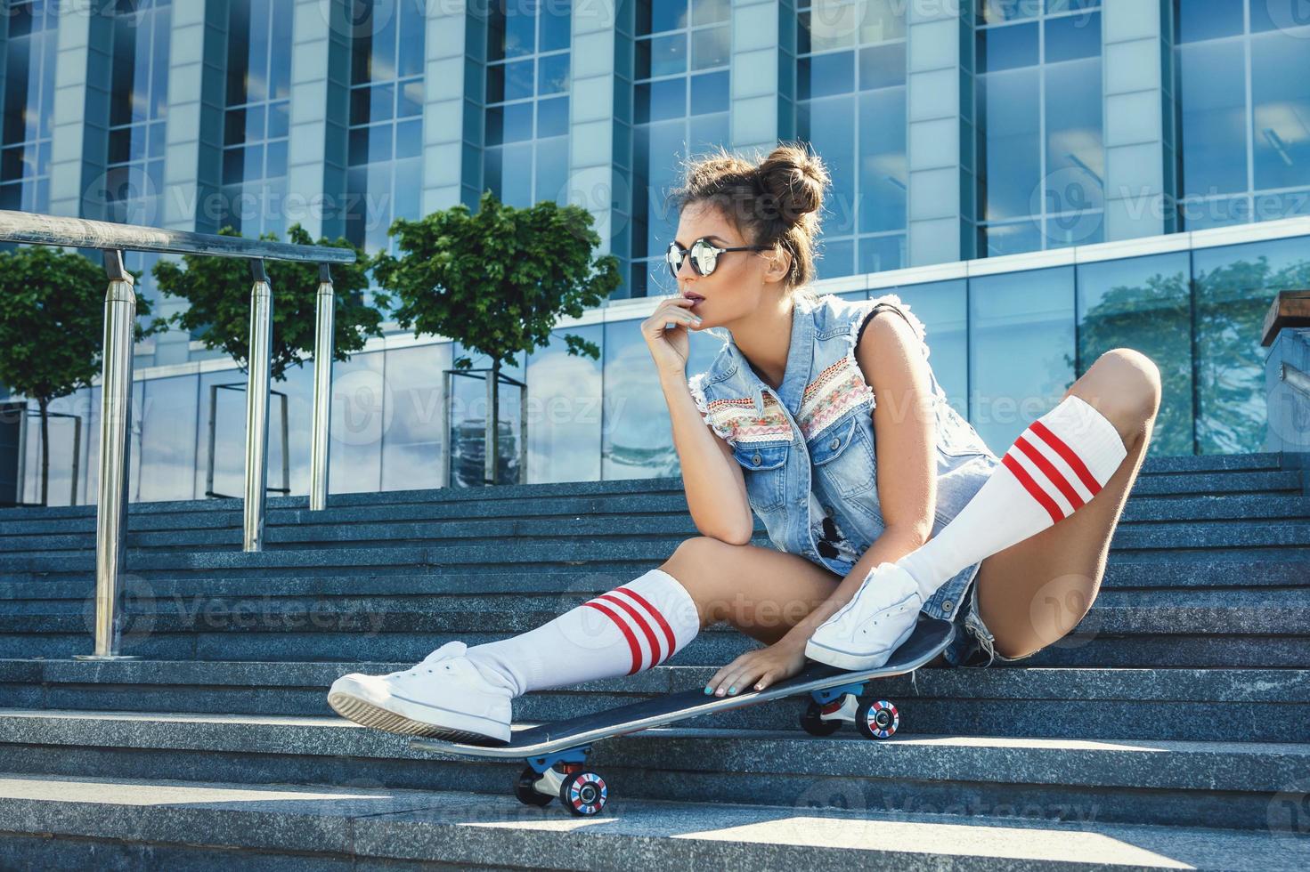 Stylish girl with a skateboard on the street photo
