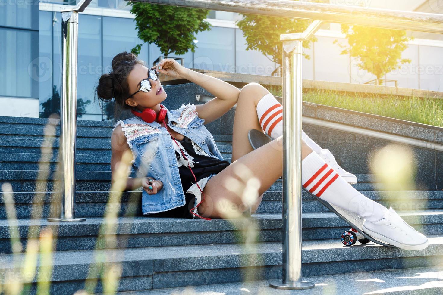 Stylish girl with a skateboard on the street photo