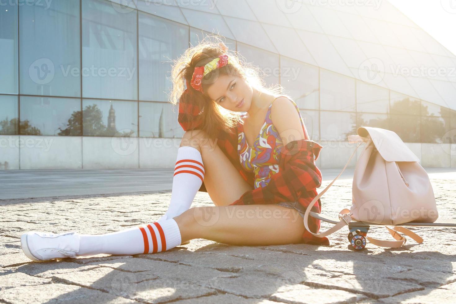 Stylish girl with a skateboard on the street photo