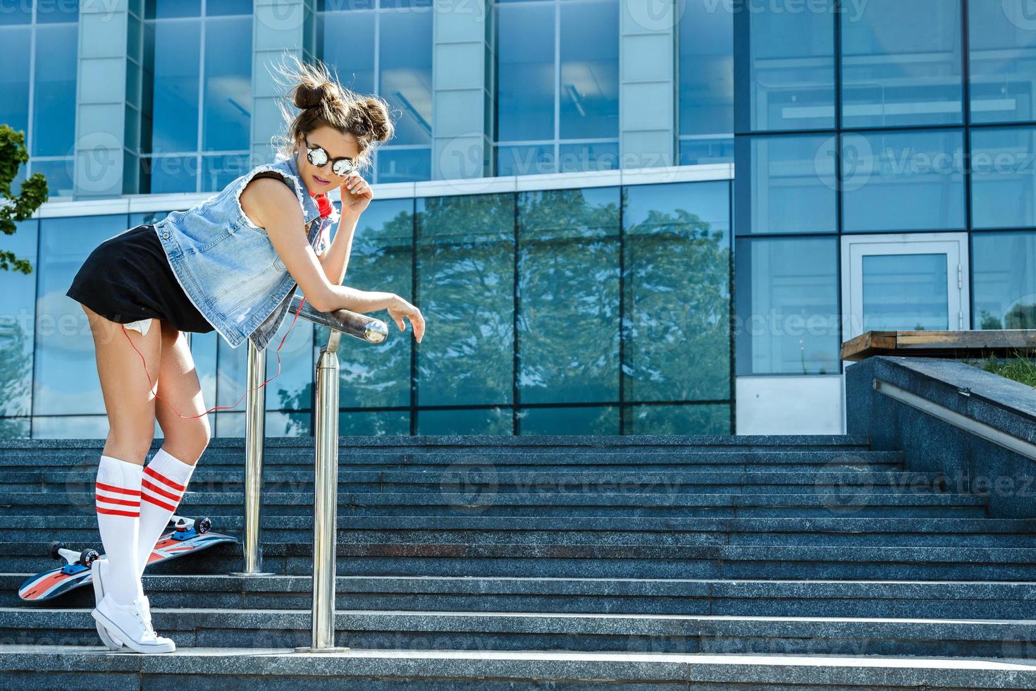 Stylish girl with a skateboard on the street photo