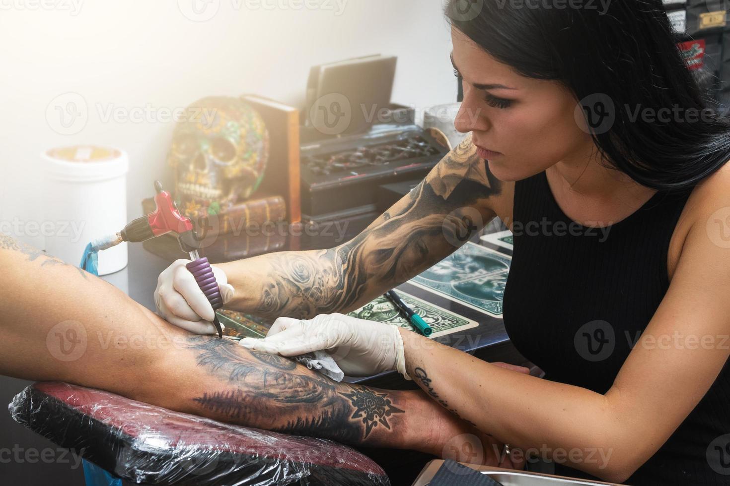 artista del tatuaje durante su trabajo foto