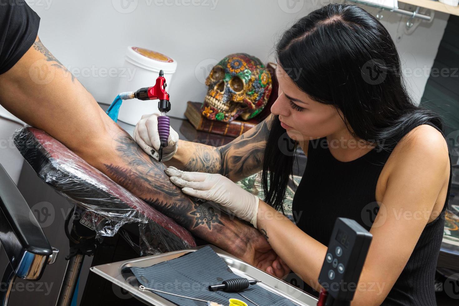 artista del tatuaje durante su trabajo foto