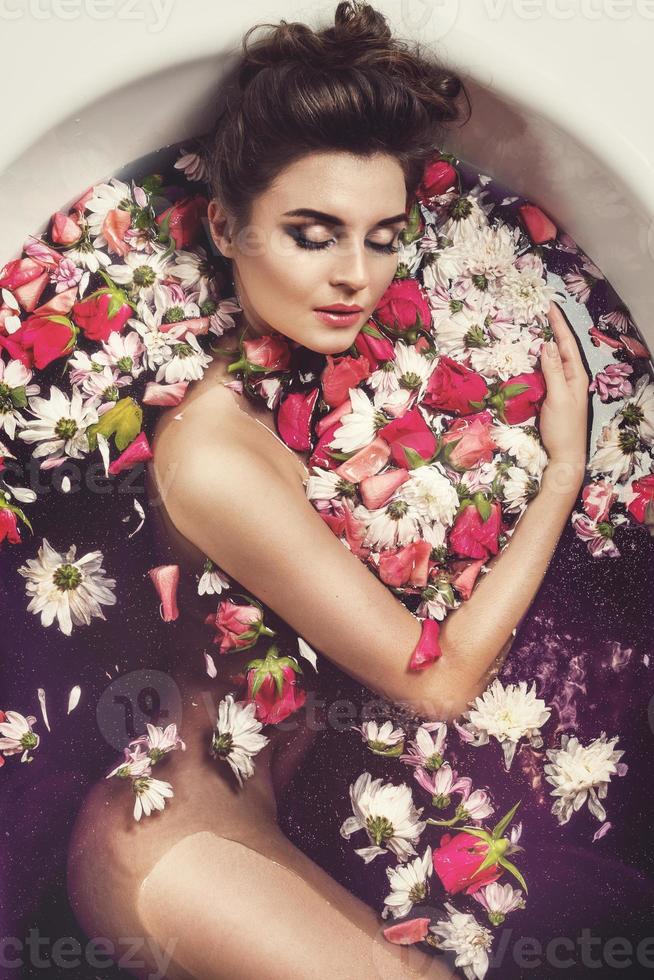 Beautiful woman in the bath with flowers photo