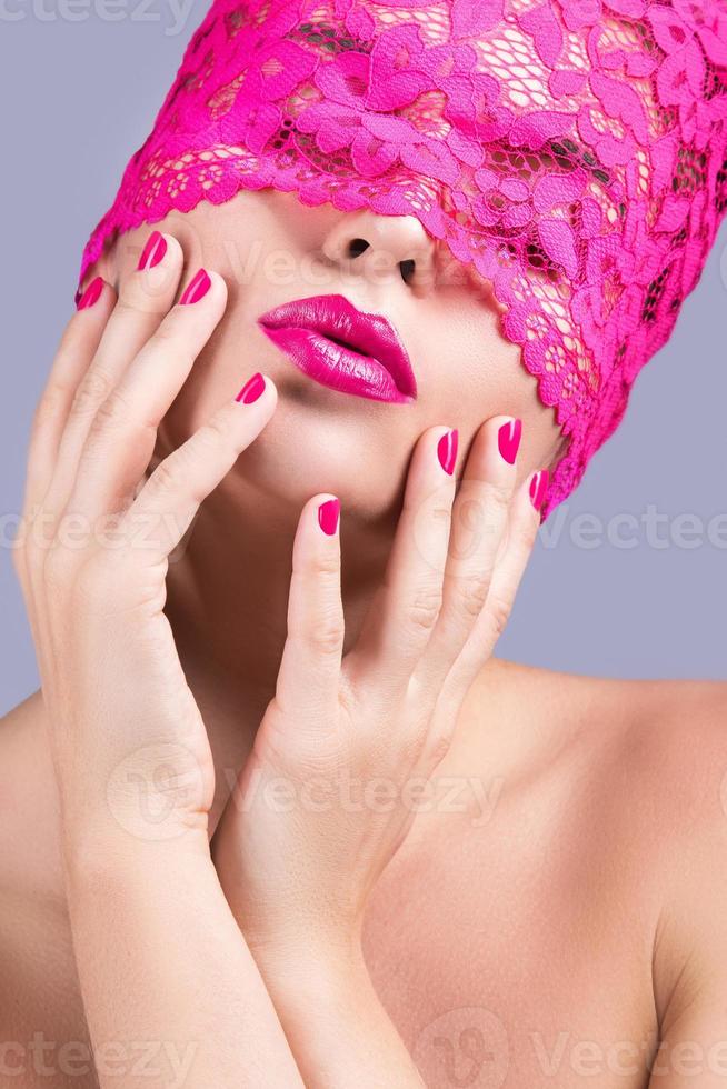 Beautiful woman with pink blindfold on her eyes photo