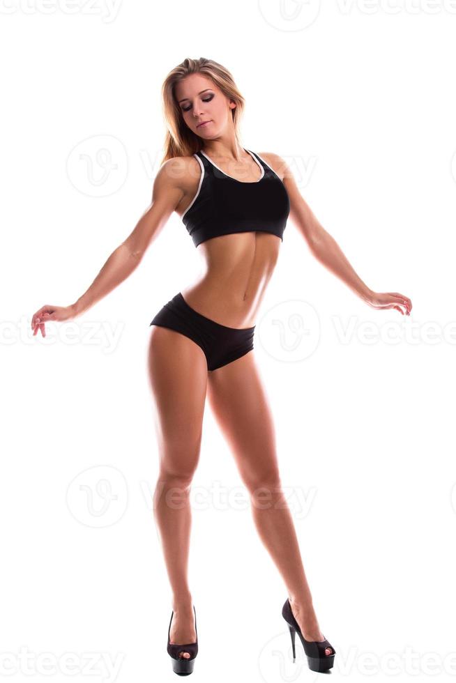 Fitness girl with muscular body posing in studio photo
