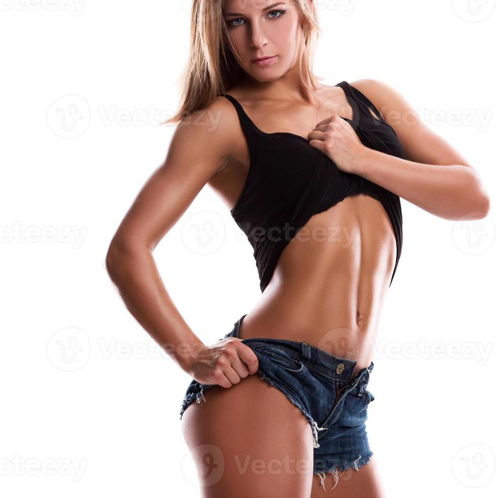 Fitness girl with muscular body posing in studio photo