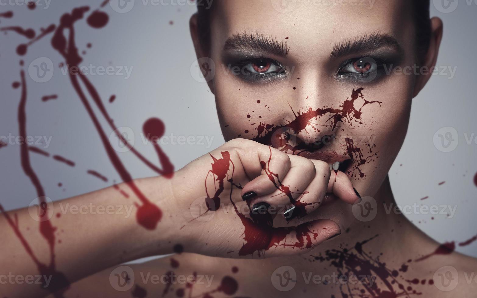 Vampire woman with blood on her face photo