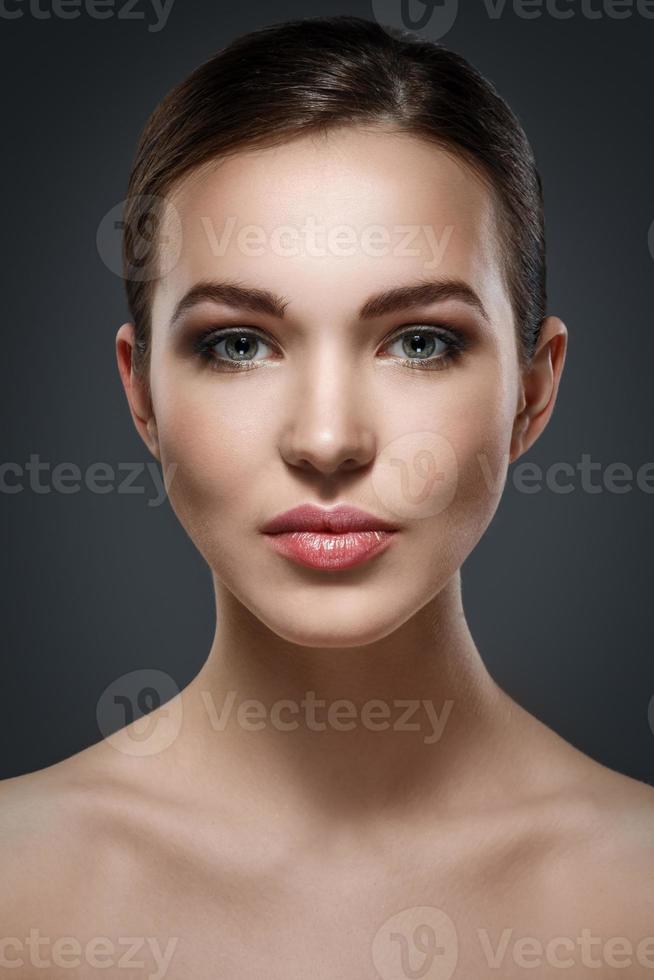 mujer hermosa joven sobre fondo gris oscuro foto