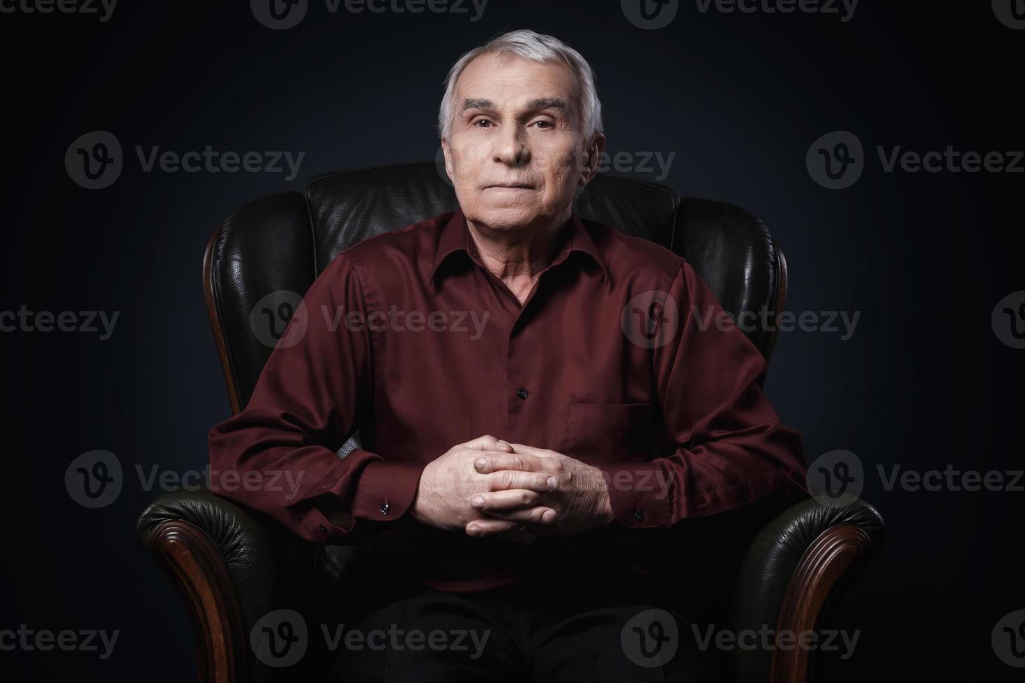 retrato de un anciano serio en un sillón foto