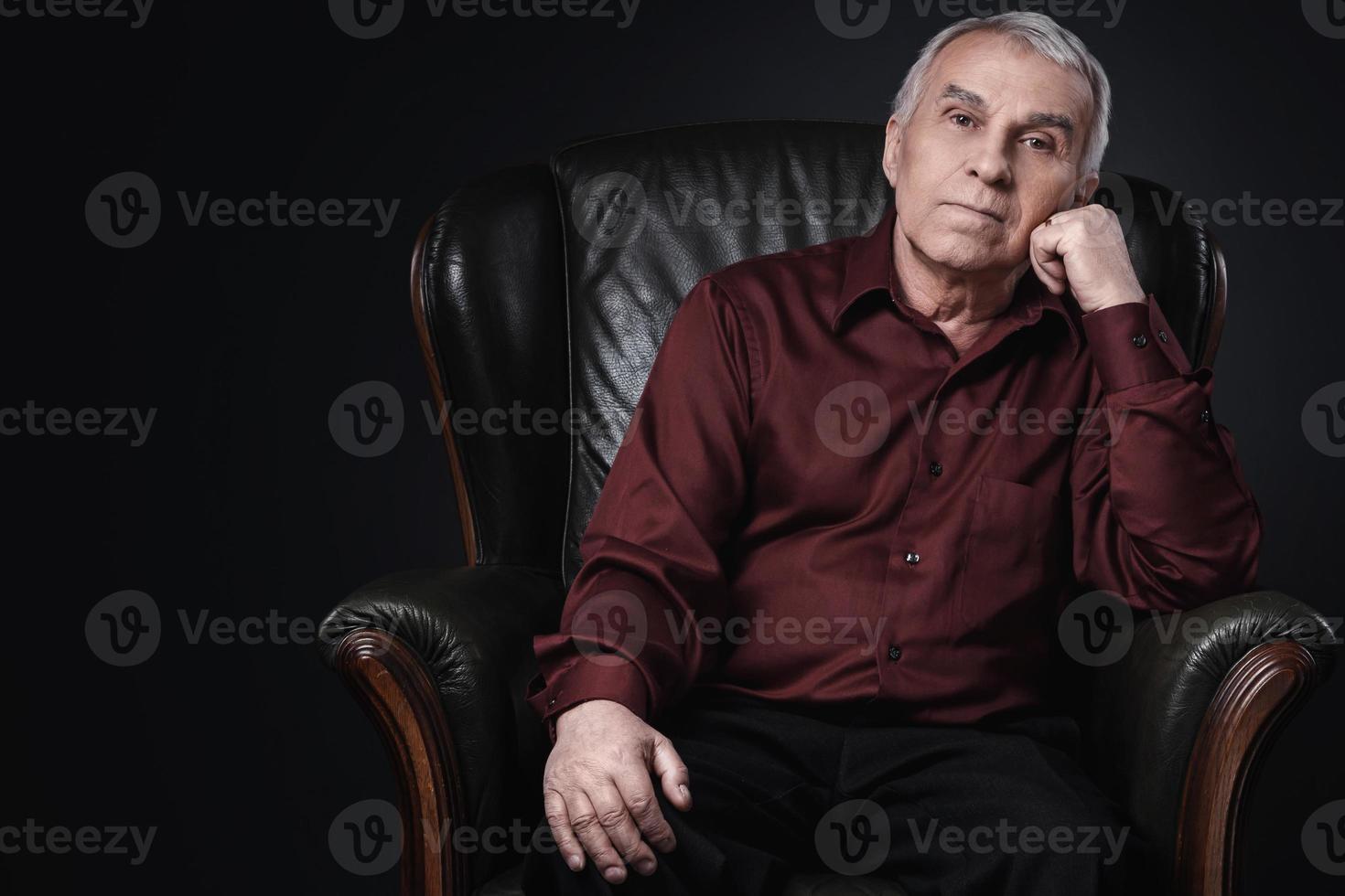 retrato de un anciano serio en un sillón foto