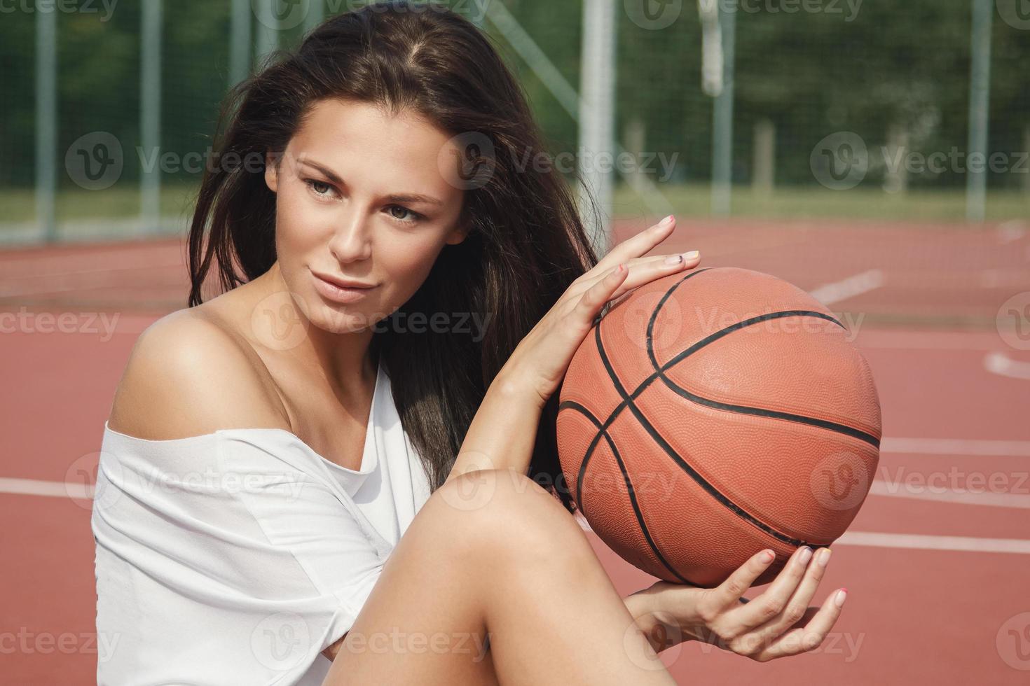 Young sexy woman with on a basketball playground photo