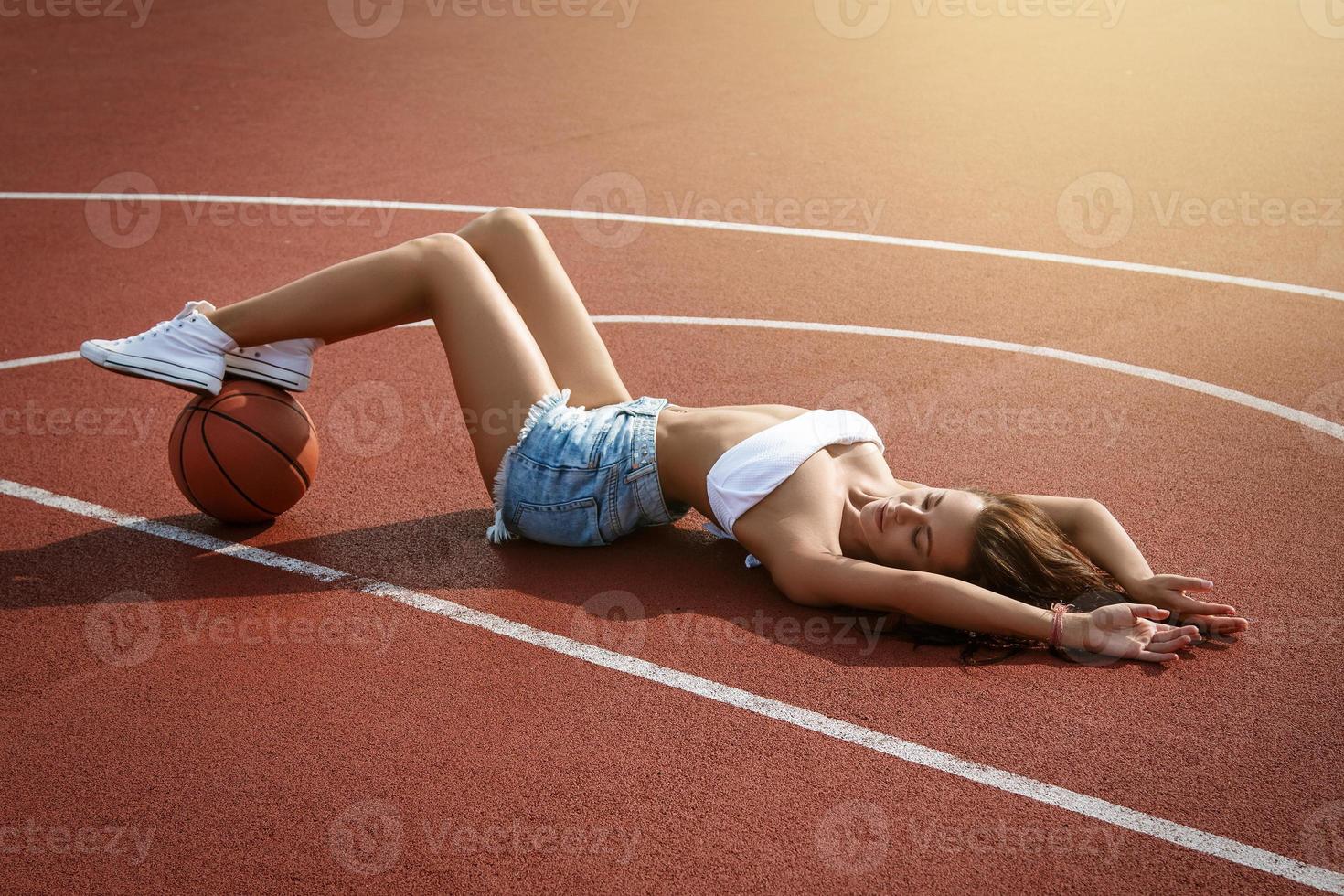 joven mujer sexy con en un patio de baloncesto foto