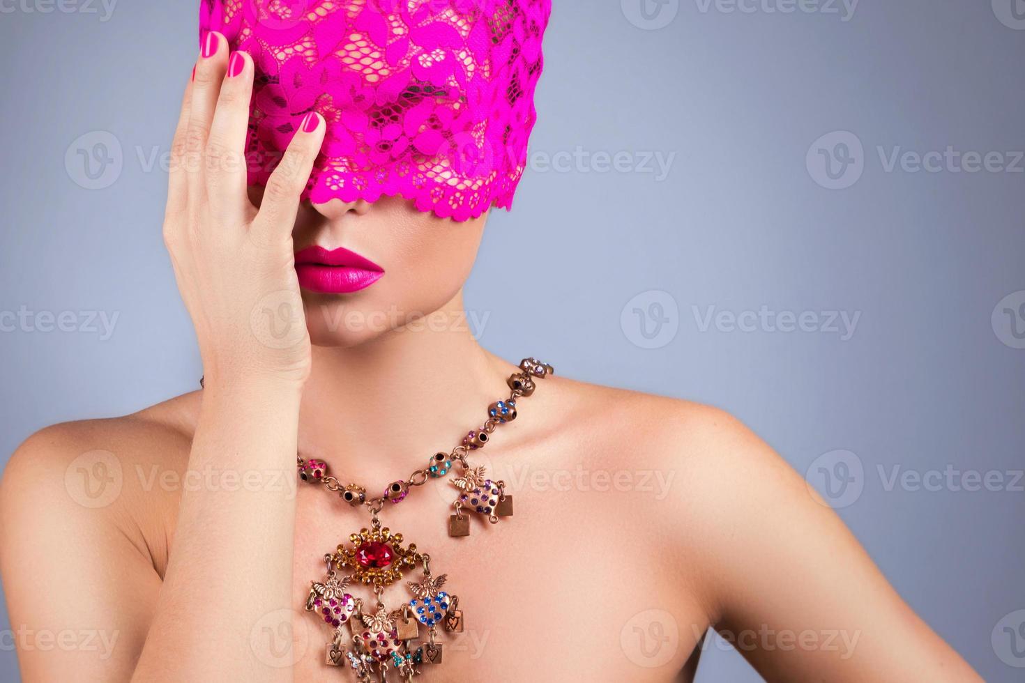 Woman with pink blindfold on her eyes photo