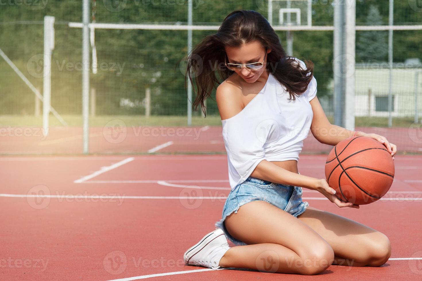 Young sexy woman with on a basketball playground photo