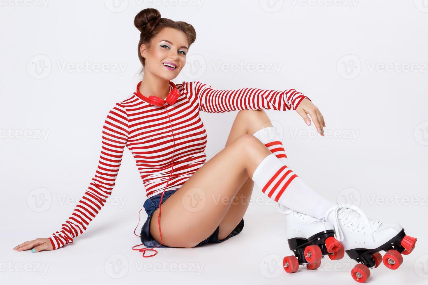 Beautiful woman in the roller-skates and with red headphones photo