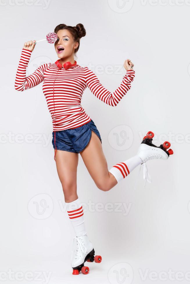 Woman in the roller-skates and with red headphones and lollipop photo