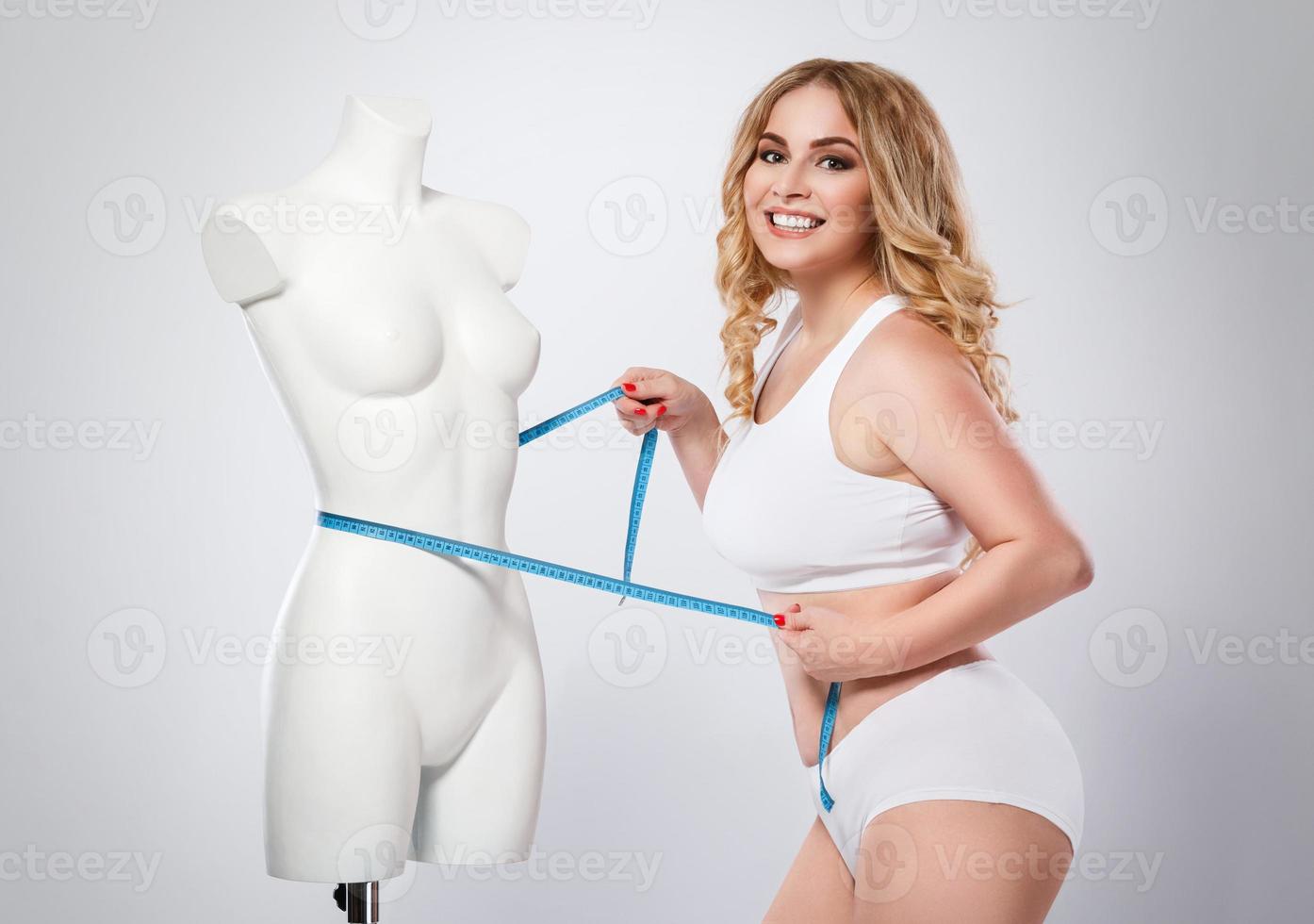 Plus size model and dummy female torso in studio photo