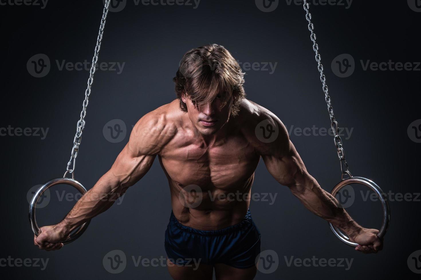 gimnasta fuerte y musculoso en los anillos foto