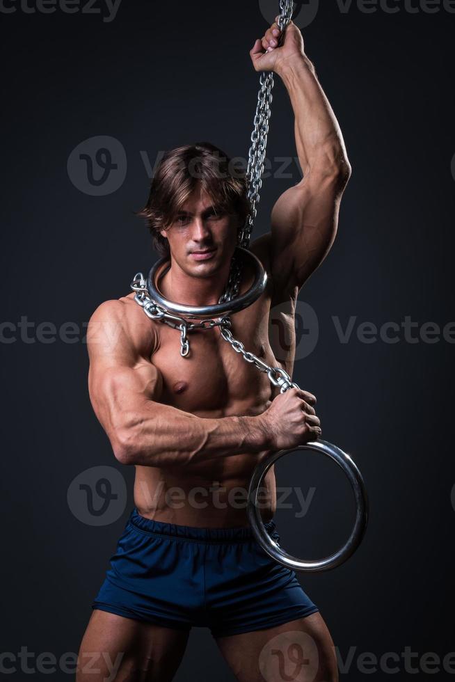 Strong muscular young gymnast guy and rings photo