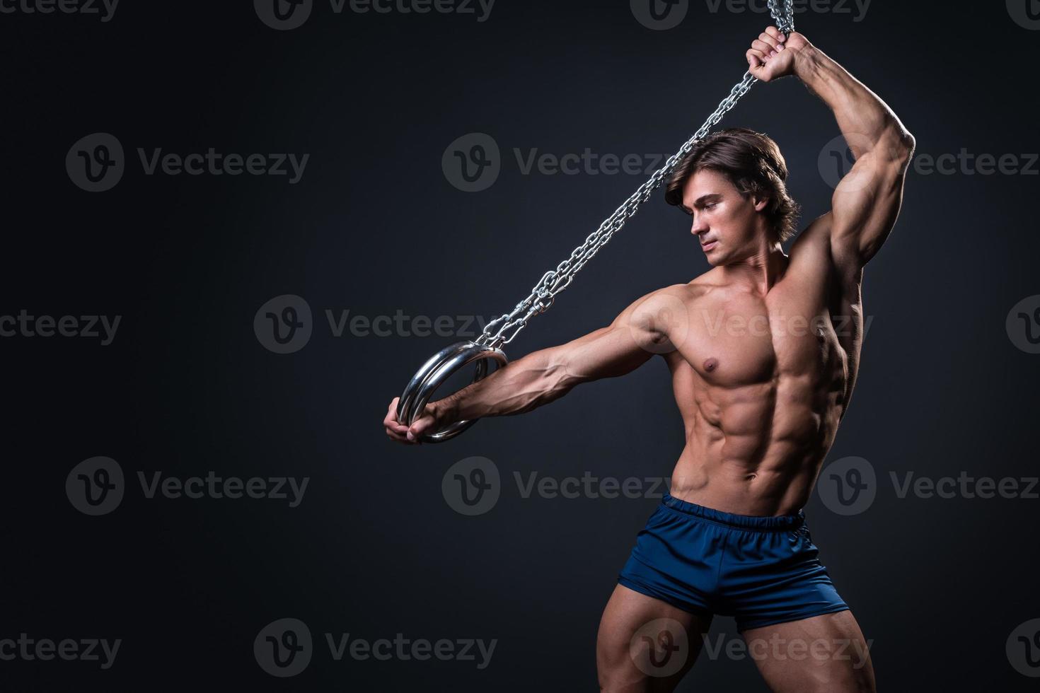 Strong muscular young gymnast guy and rings photo