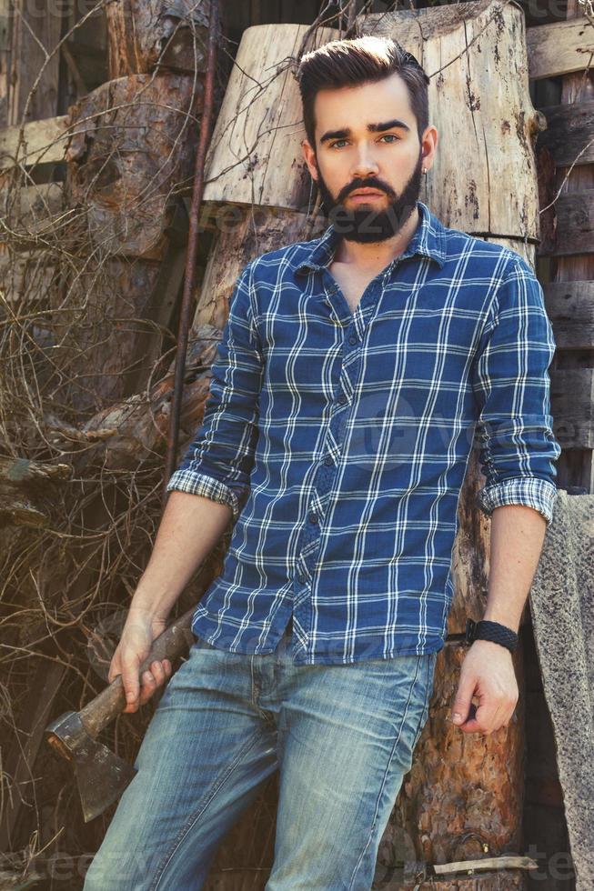 guapo hombre barbudo en camisa a cuadros con hacha foto