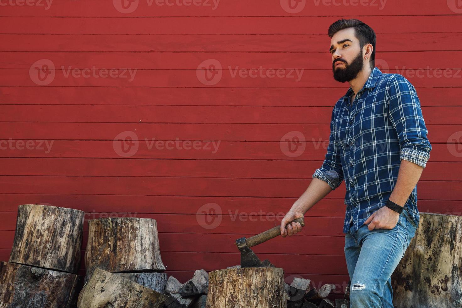 Handsome bearded man in checkered shirt with axe photo