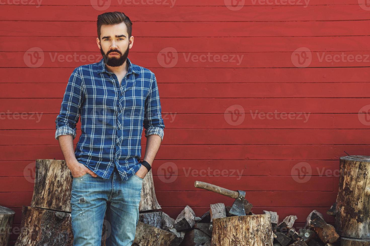 Handsome bearded man in checkered shirt with axe photo