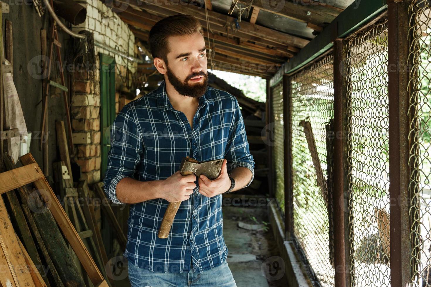 Handsome bearded man in checkered shirt with axe photo