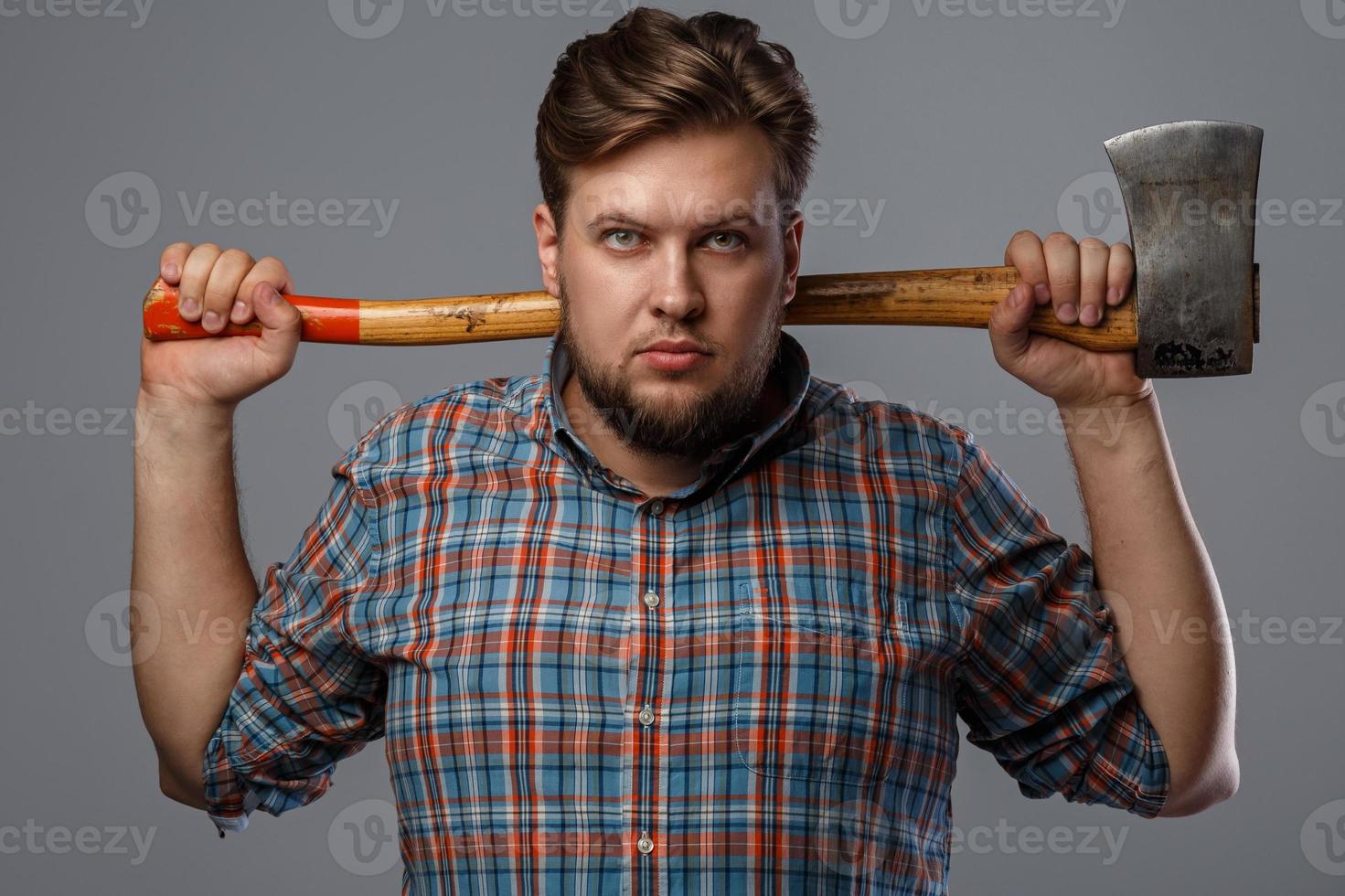 Bearded man with axe posing in studio photo