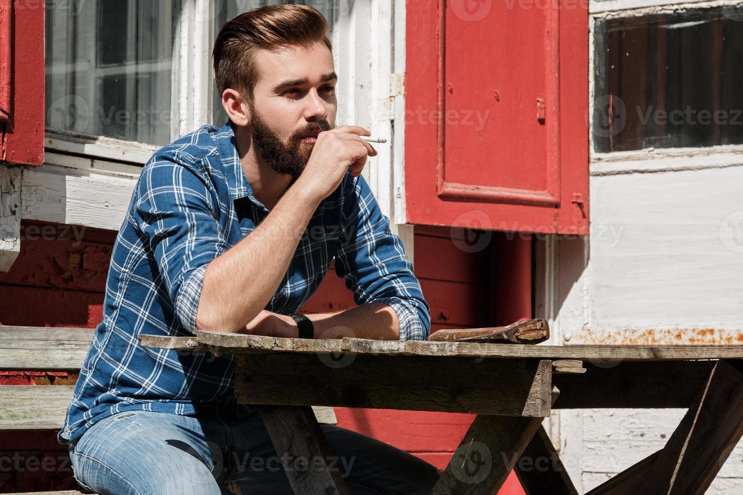 Man is smoking cigarette durring his rest break photo