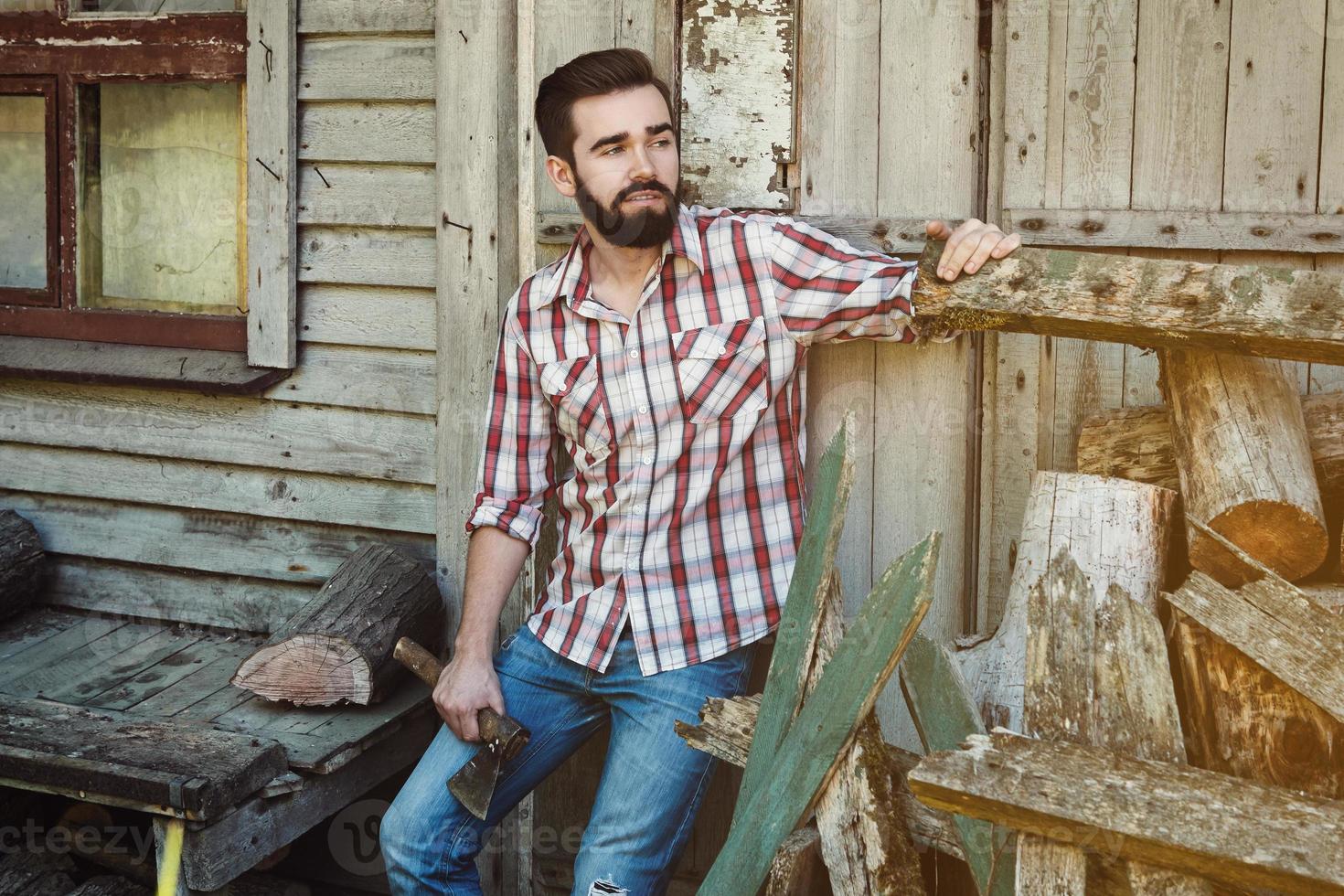Handsome bearded man in checkered shirt with axe photo