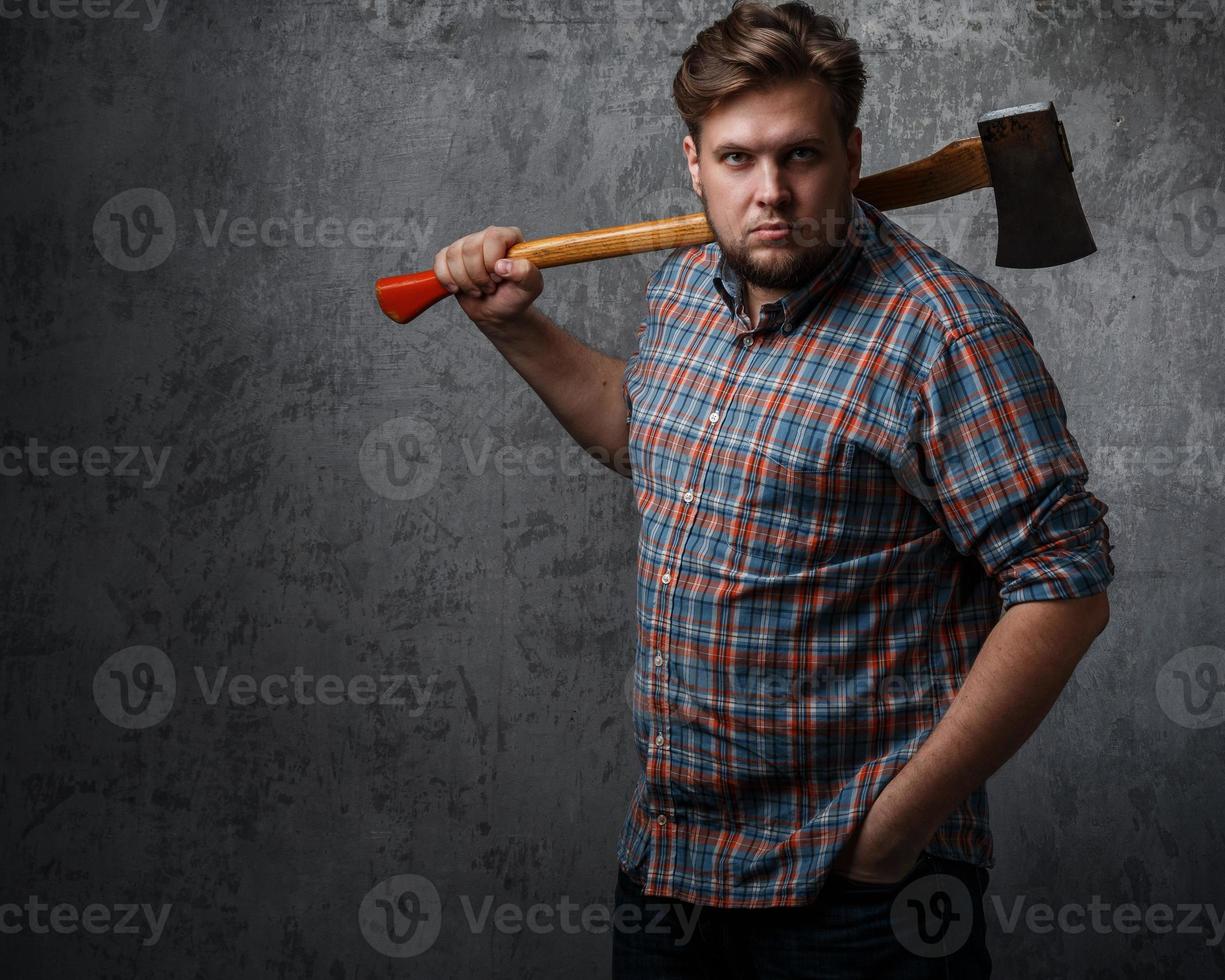 hombre barbudo con hacha posando en el estudio foto