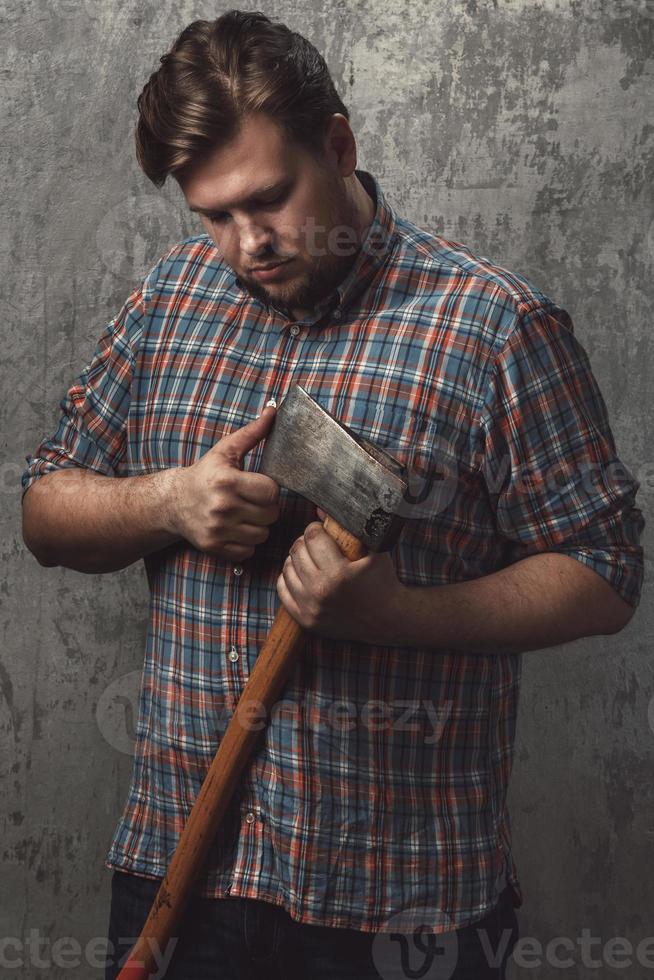 Bearded man with axe posing in studio photo