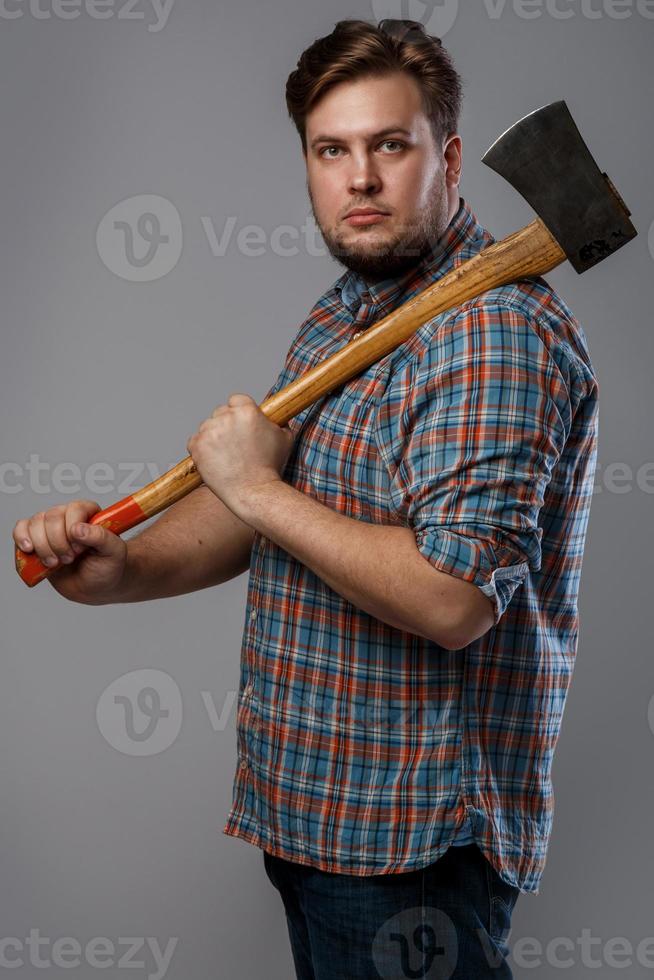 Bearded man with axe posing in studio photo