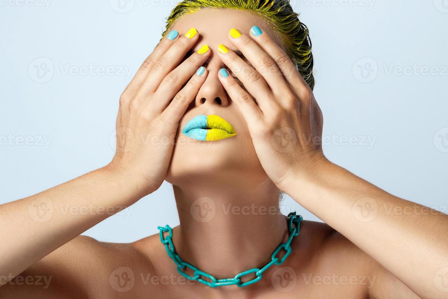 Beautiful woman with yellow hair and colorful nails and lips photo