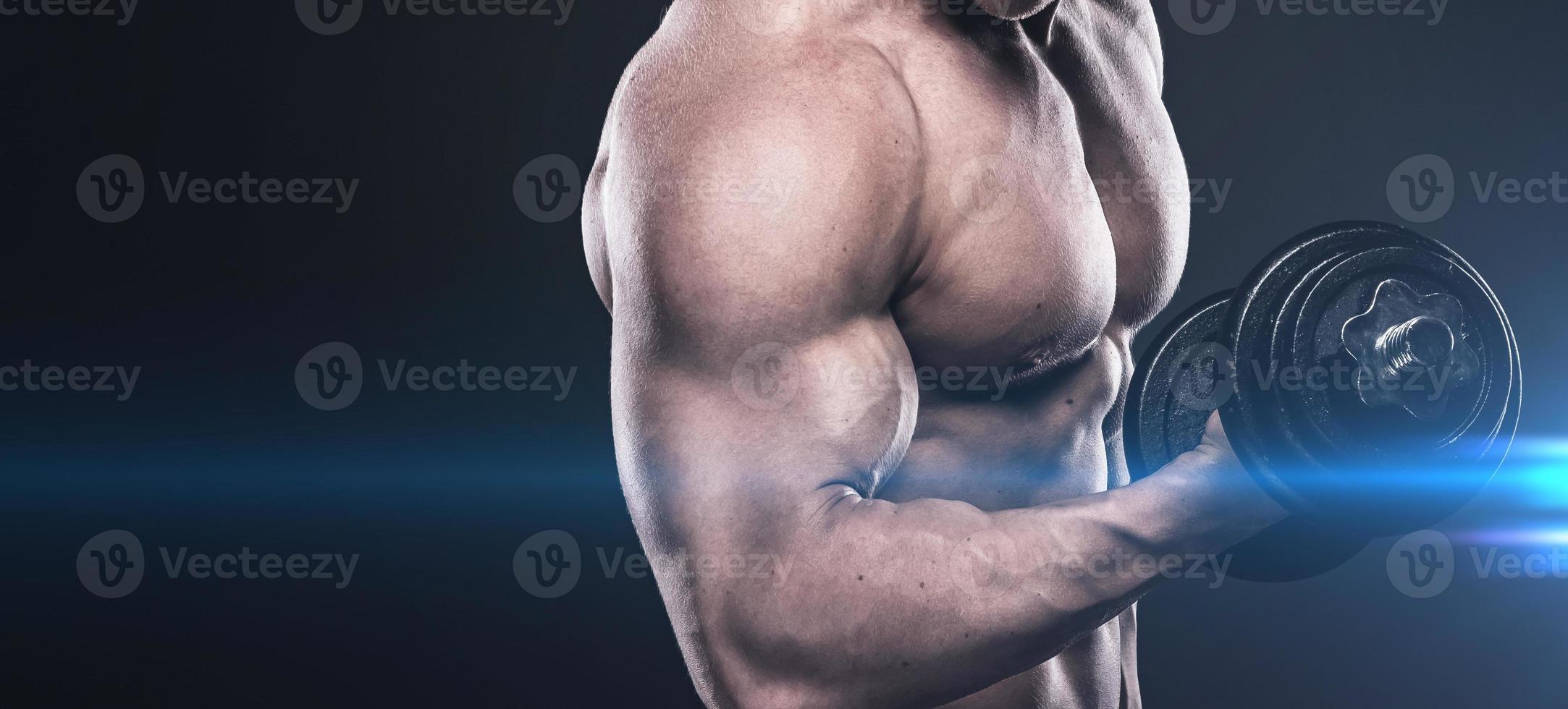 Bodybuilder doing exercises with dumbbells photo