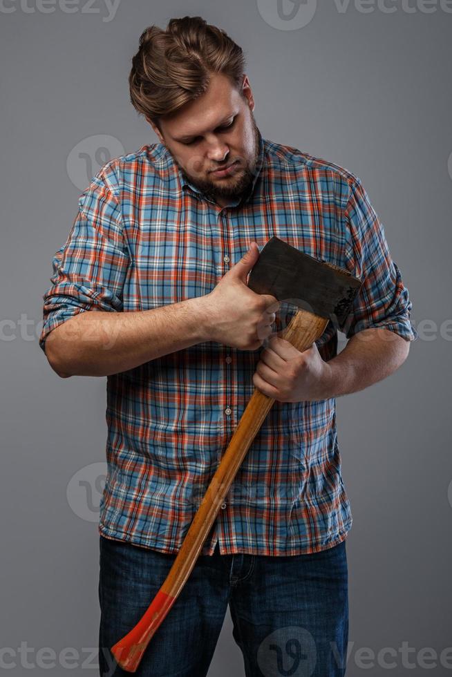 Bearded man with axe posing in studio photo